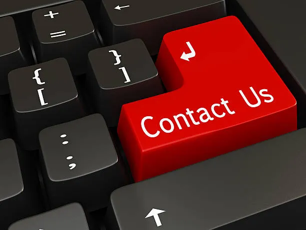 Contact Us Today Male MMI Staff in Warehouse Sitting in Front of Computer Monitor