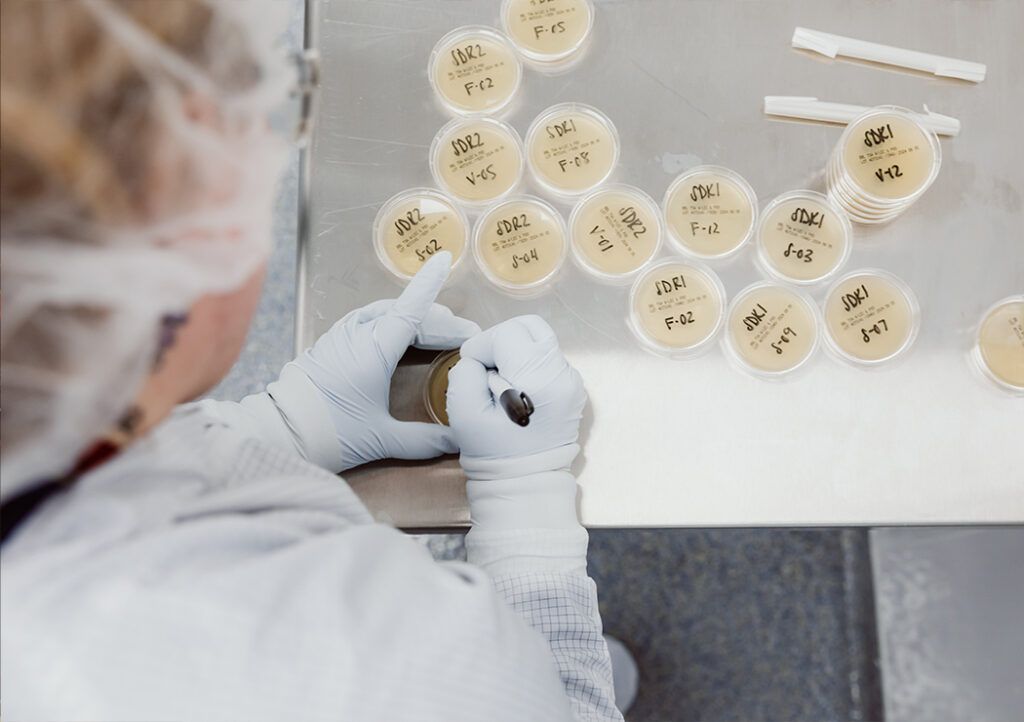Specialized Sampling and Dispensing Services for Clients MMI Employee in Sterile Gear Performing Sampling and Dispersing Services For Clients