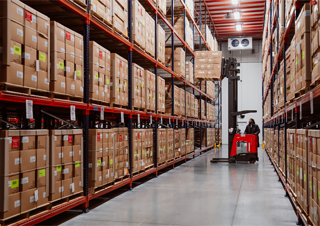 Proprietary State Stockpile as a Service (SSaaS) Solutions for Efficiency Worker with Forklift in MMI Warehouse Surrounded by Shelves of Boxes
