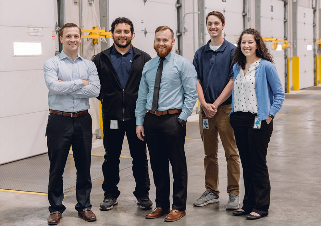 Smiling Men and Women MMI Workers Standing inside the Warehouse Facility
