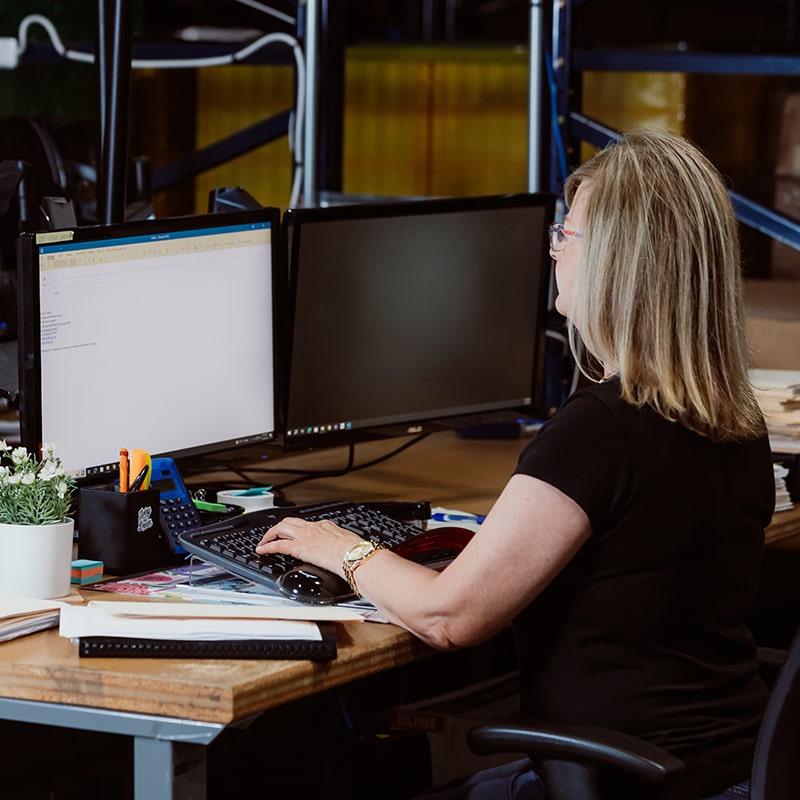 Worker Sitting in Front of Computers Offering Direct Support to Clients