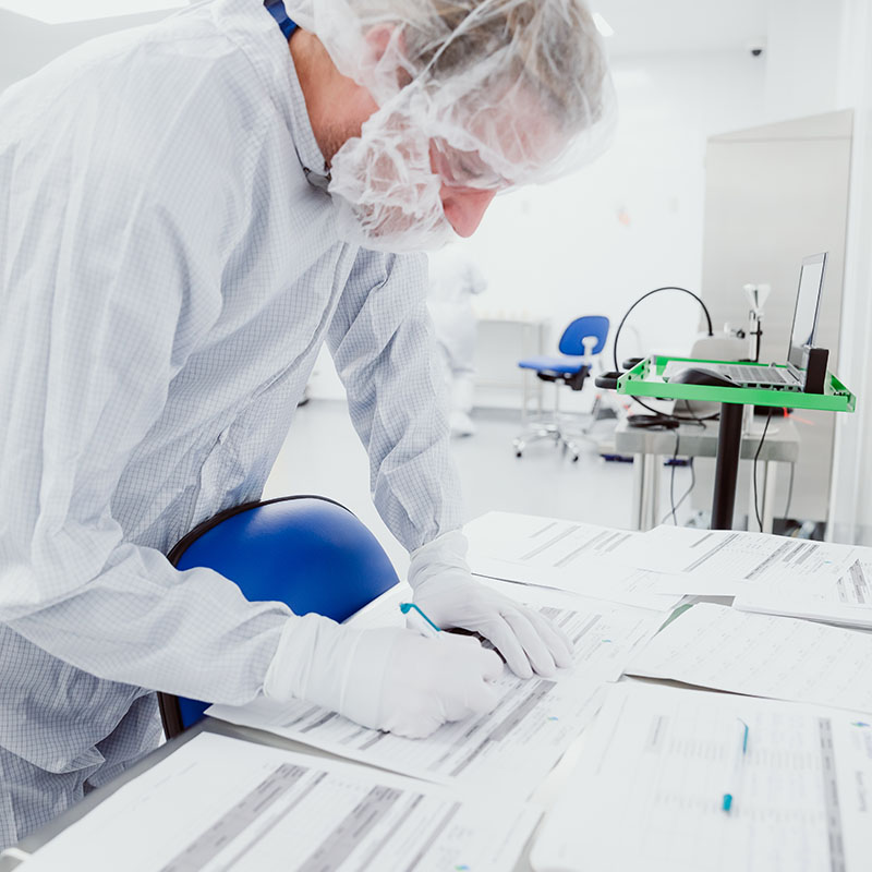 Worker in Clean Gown Performing Compliant Dispensing Measures